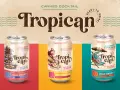 Trzy puszki gotowych drinków "Tropican" o różnych smakach: ananasowym, pomarańczowym i marakujowym.