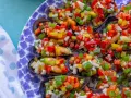 Mejillones a la vinagreta, cubiertos con una colorida mezcla de pimientos y cebolla picados. Un plato fresco y vibrante.