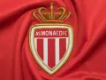 Herb AS Monaco FC na czerwonym tle. Duma z osiągnięć i rankingi klubu.