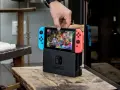 Mano insertando la Nintendo Switch en su base, lista para jugar Mario Kart 8 Deluxe, uno de los mejores juegos estrategia switch.