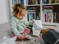 Kleines Kind macht alles kaputt: Erde und ein umgekippter Blumentopf liegen auf dem Boden.