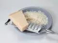 Kawałek parmezanu i starty ser na talerzu. Zastanawiasz się, czy parmezan można mrozić? Tak, można go mrozić, zachowuje wtedy smak.
