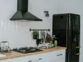 A clean vent hood filter is crucial for kitchen safety and efficiency. This image shows a modern kitchen with a black vent hood over a gas stove.