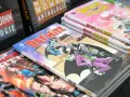 Fumetti DC Comics impilati, tra cui "Bat-Mite" e "Batman Little Gotham". Un lavoro da fumettista che prende vita.