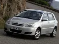 Srebrna Toyota Corolla E12 na krętej drodze, z kamienistym zboczem w tle.