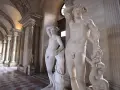 Les sculptures en marbre d'Amour et Psyché de Canova, dans un musée avec des colonnes et un sol à damier.