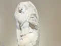 Niedokończony posąg Michała Anioła, ukazujący fragment ludzkiego ciała wyrzeźbionego z marmuru.