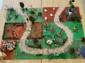 Kinder gestalten einen Kreuzweg mit Spielfiguren und Naturmaterialien. Kleine Szenen zeigen Stationen des Leidenswegs.