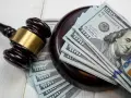 Młotek sędziowski i banknoty 100 dolarów symbolizują przesłanki upadłości.