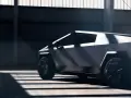 Tesla Cybertruck w ciemnym wnętrzu, widok z boku, podkreślony przez światło i cień.