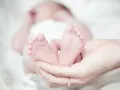 Delikatne stópki noworodka w dłoniach rodziców. Czas na urlop okolicznościowy urodzenie dziecka, pełen miłości i czułości.