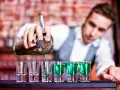 Barman nalewa zielony alkohol do kieliszków.