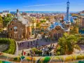 A vibrant view of Park Güell in Barcelona, with its iconic mosaic-covered benches and whimsical buildings. This is the perfect place to start your trein naar Barcelona adventure.