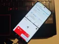Telefon z aplikacją Magisk, która jest kluczowa, by dowiedzieć się, jak zrootować telefon. Widoczny też portfel z kartą płatniczą.