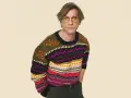 Mann mit gelber Brille trägt einen bunten Pullover aus Wolle, schleudern von Mustern.