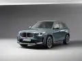 BMW iX1 w kolorze zielonym, widok z przodu, na szarym tle.
