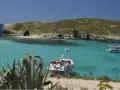 Malta wakacje: turkusowa woda, skaliste wybrzeże z jaskiniami i łodzie. Idealne miejsce na relaks.