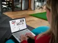 Partecipa a webinar gratuiti con attestato, interagendo con colleghi da remoto tramite videochiamata su laptop.