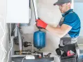 Instalator sprawdza podzespoły kotła gazowego. Zastanawiasz się, ile kosztuje piec gazowy?