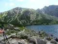 Malownicza kozia dolina z jeziorem i skalistymi zboczami gór. Turyści odpoczywają nad wodą.
