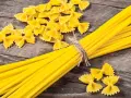 Makaron z mąki durum i zwykłej pszennej. Farfalle i spaghetti na drewnianym tle.