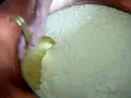 Mélange du caillé dans une cuve en cuivre, étape clé après la traite des vaches pour la fabrication du fromage.
