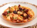 Un delicioso pulpo a la mugardesa, con patatas tiernas y un sofrito sabroso, adornado con perejil fresco.