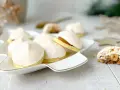 Zarte eis baiser Kekse mit einer cremigen Füllung auf einem festlichen Teller, bereit zum Genießen.
