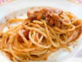 Spaghetti alla chitarra con sugo di carne, un piatto ricco e saporito, pronto per essere gustato.