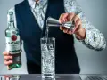 Barman nalewa rum Bacardi do szklanki z lodem, przygotowując Cuba Libre. Jaki rum do drinka? Bacardi Carta Blanca.
