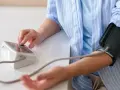 Kobieta mierzy ciśnienie krwi, monitorując potencjalne nadciśnienie objawy.