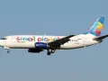 Samolot linii Small Planet Airlines z kolorowym motywem globu na ogonie.