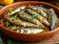 Sardinas en escabeche, un plato tradicional con cebolla y perejil, servido en una cazuela de barro.