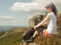Kobieta odpoczywa na szczycie, podziwiając widok na Bieszczady. To miejsce, które warto zobaczyć, oferuje niezapomniane krajobrazy.
