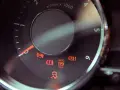 Dashboard lights illuminate, including ABS, brake warning, and a car skidding, indicating a potential issue with the slip indicator light.
