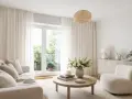 Ljust vardagsrum med en takmonterad gardinskena som elegant håller upp de böljande vita gardinerna.