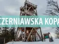 Drewniana wieża widokowa na szczycie Czerniawska Kopa, otoczona zimowym lasem.