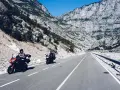 Motocykliści przemierzają malowniczą drogę w Albanii, mijając skaliste zbocza i ukryte bunkry z czasów komunizmu.
