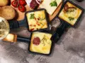 Pyszne, roztopione sery z dodatkami w patelenkach do raclette. Idealne na wspólne wieczory, gdy zastanawiasz się, co na raclette.