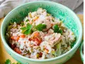 Reissalat mit Thunfisch, Tomaten und Gurken, garniert mit Petersilie, in einer grünen Schüssel. Ein leichter und leckerer Salat.