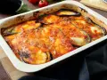 Bandeja de berenjenas a la parmesana recién horneadas, con queso derretido y salsa de tomate burbujeante.