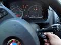 Ręka wsuwa kluczyk do stacyjki, by dowiedzieć się, jak odpalic auto. Na desce rozdzielczej świecą kontrolki.