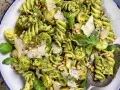 En närbild av en härlig pastasallad med pesto, pinjenötter, parmesan och färsk basilika. Perfekt för en lätt lunch.