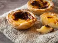 Tre krämiga portugisiska bakelser med karamelliserad yta, en klassiker inom portugisisk mat.