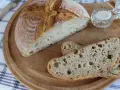 Chleb żytni na zakwasie, pokrojony w kromki, z solniczką na drewnianej desce.