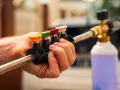 Choosing the right nozzle to pressure wash car is key. This hand holds a selection of colored tips for a pressure washer wand, ready for detailing.