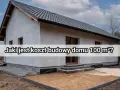 Nowy dom w budowie, szary tynk, ciemny dach. Jaki jest koszt budowy domu 100 m² w 2025 roku?