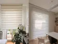 Due tende moderne, una a rullo a strisce alternate e una a pacchetto, mostrano la loro lunghezza ideale per ogni ambiente.