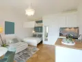 Gemütliche Wohnung einrichten: Bett, Sofa, Küche und Esstisch in einem hellen Raum.