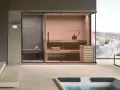 Interno moderno con sauna in legno, vista panoramica innevata. Qui si fa relax e benessere in spa.